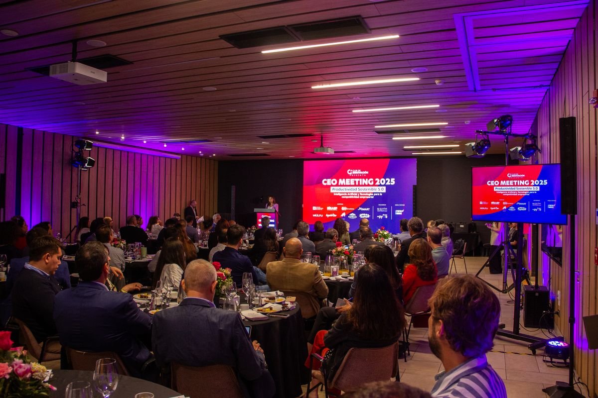 Salón de CEO Meeting 2025 con ejecutivos en mesas frente al escenario
