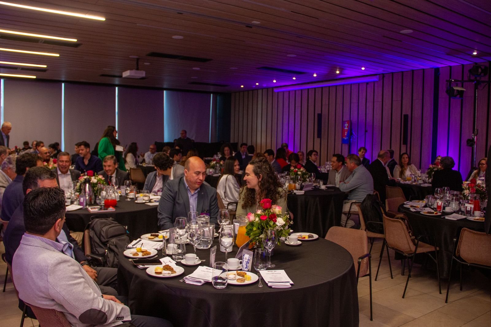 Mesas con desayuno servido y ejecutivos conversando en CEO Meeting 2025